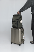Person holding the handle of a rolling suitcase with the Olive Cruiser on top