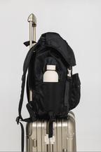 Side view of the Black Cruiser on a suitcase, with a bottle in the side pocket